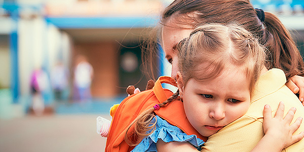 Criança no colo da mãe com carinha de medo. 