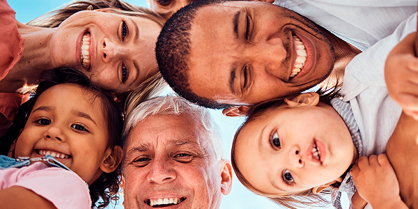 Rosto de mãe, pai, avô e crianças sorrindo em atividades em família. 